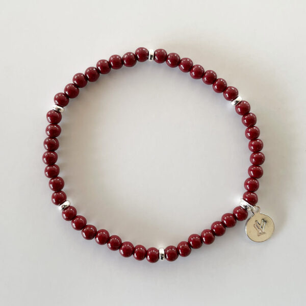 Stilrent armband med små pärlor i djupröd imiterad cinnabarsten och platinapläterade 925 sterling silver detaljer, designat av svenska Livingstone Wikh Accessories.